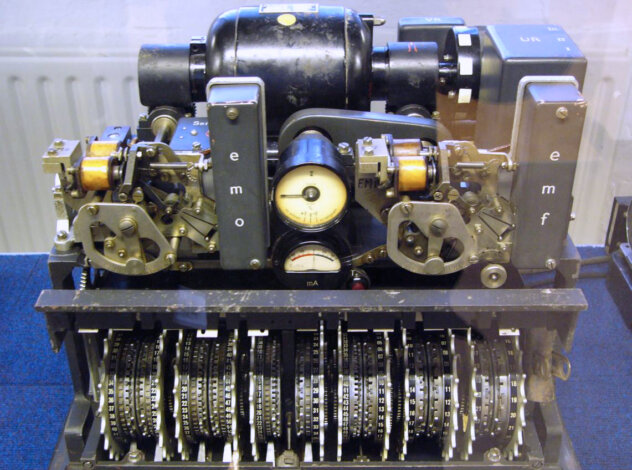 Close-up of a historic cipher machine with gears, dials, and labeled components.